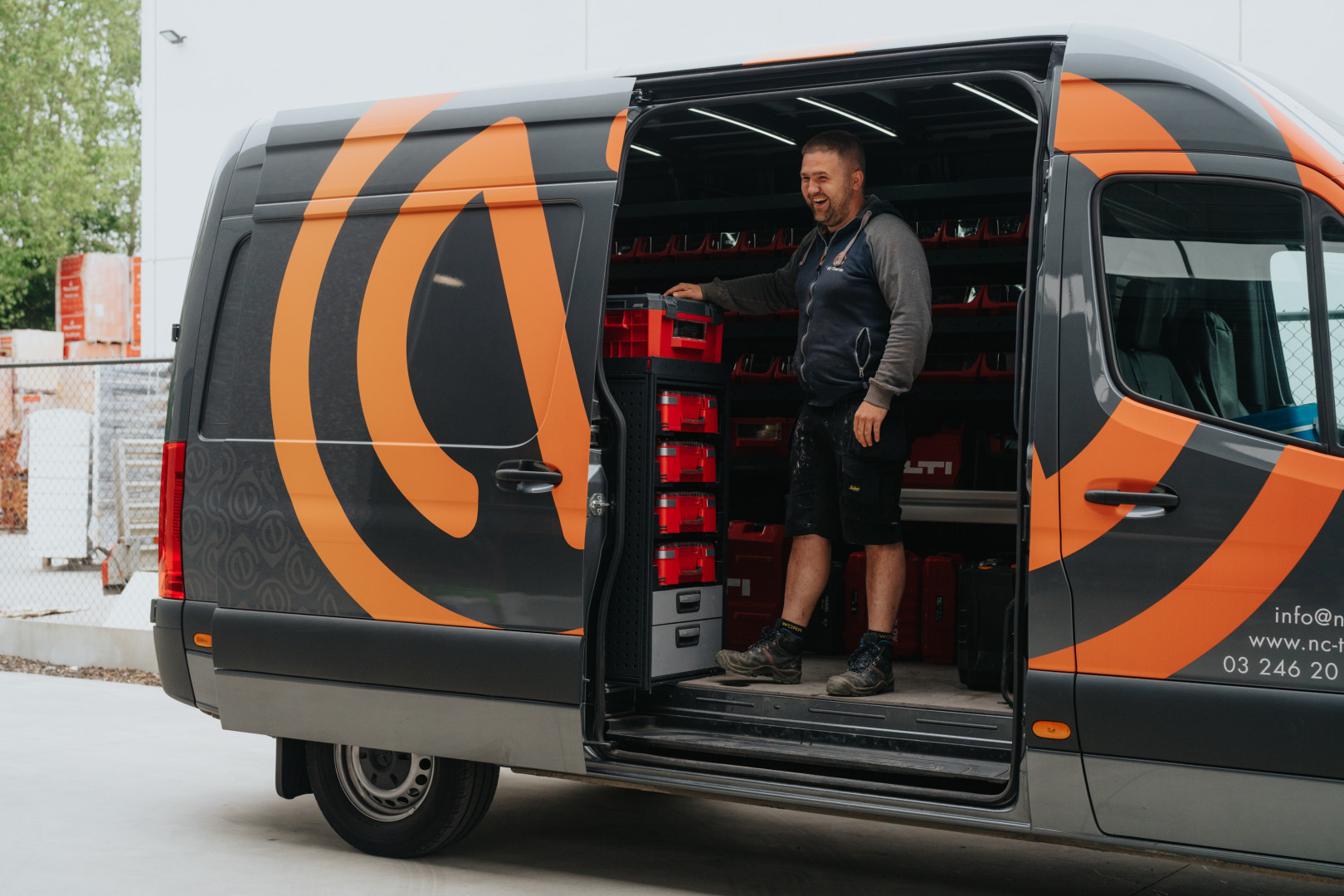 Bestelwagen NC Therm Medewerker van NC Therm bij bestelwagen met materiaal en logo