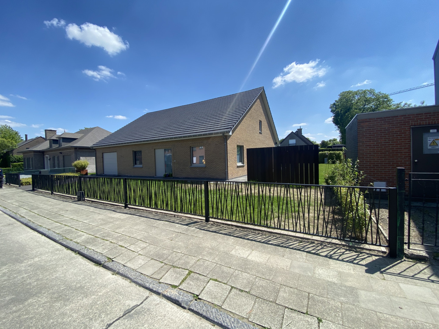 Moderne metalen tuinomheining in maatwerkdesign Zwarte metalen tuinomheining met speels design bij een woning in Sint-Niklaas, geplaatst door Laswerken Bellon.