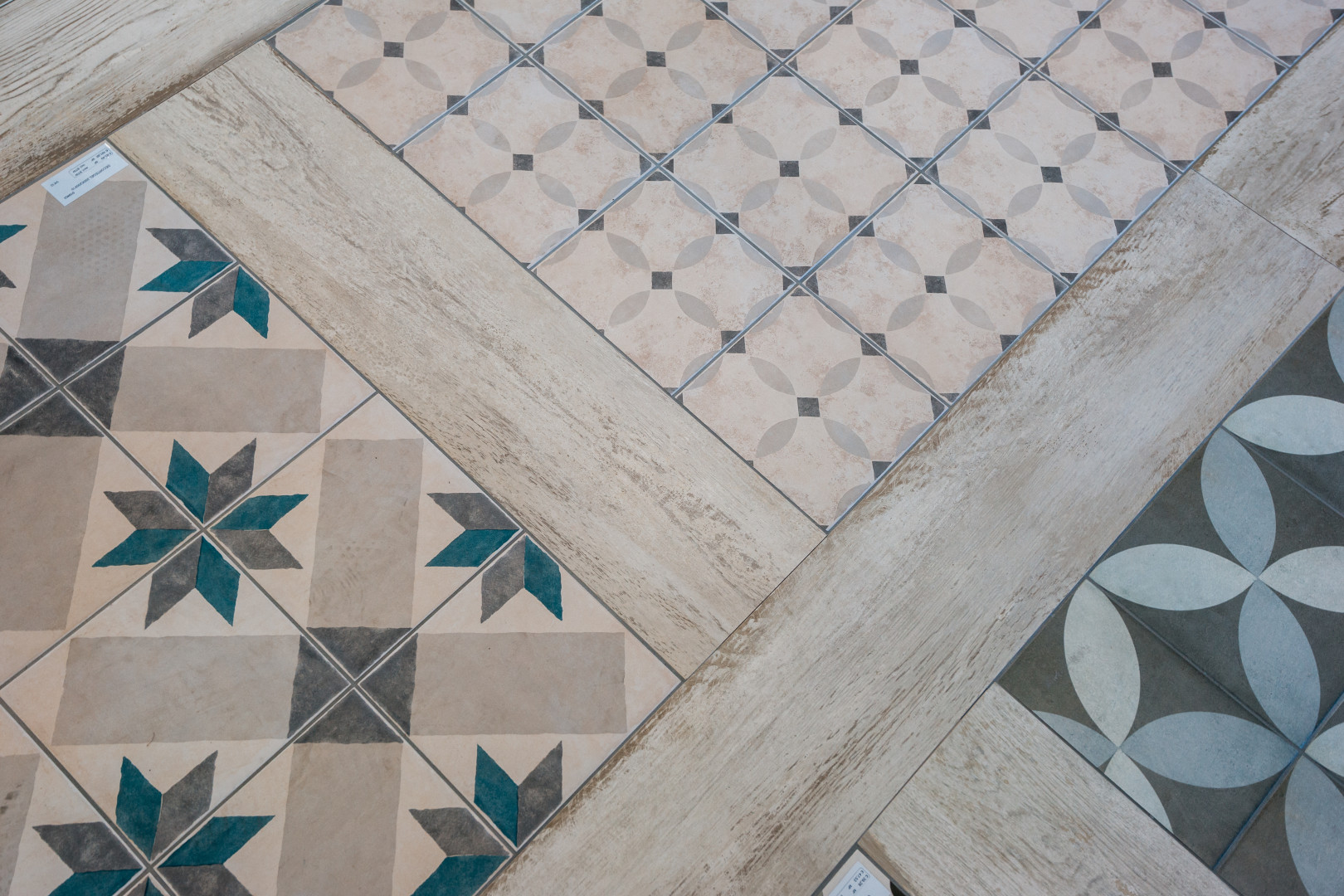Decoratieve patroontegels met houtlook accenten Detail van kleurrijke patroontegels gecombineerd met houtlook keramische tegels in de showroom van Tegelhandel Kwanten in Pelt.