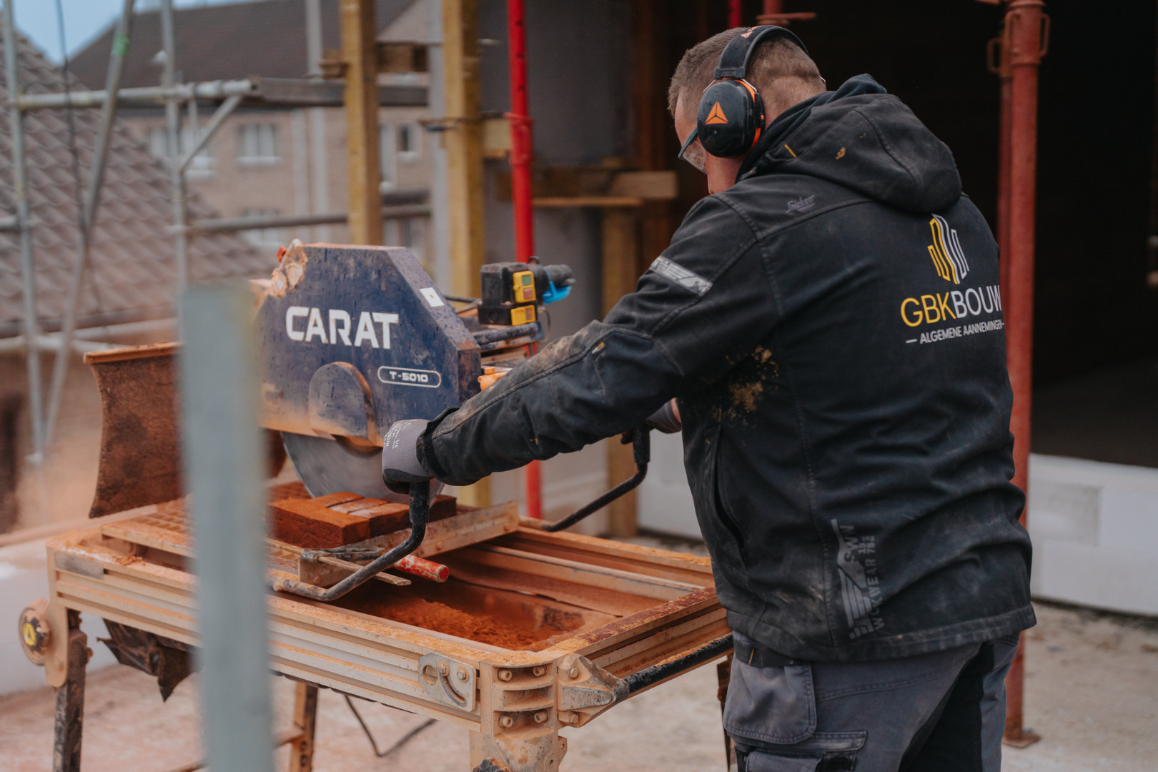 Bakstenen zagen op de werf bij GBK Bouw Medewerker van GBK Bouw zaagt bakstenen op maat met een CARAT-zaagmachine tijdens de ruwbouwfase van een nieuwbouwproject.