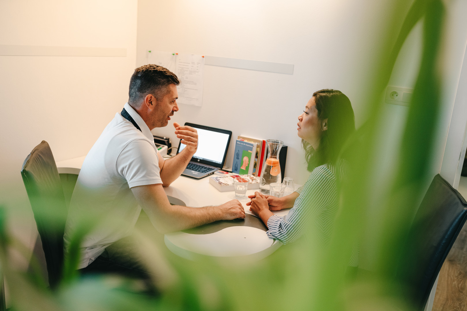 Intakegesprek spijsverteringsklachten - Chinese geneeskunde Joop Munnik met cliënt tijdens een intakegesprek aan zijn bureau.