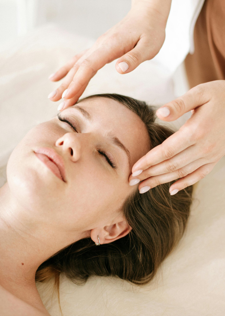 Kobido massage voor natuurlijke huidverjonging Vrouw geniet van een ontspannende Kobido gezichtsmassage met gesloten ogen, uitgevoerd met zachte handbewegingen in een rustgevende omgeving.