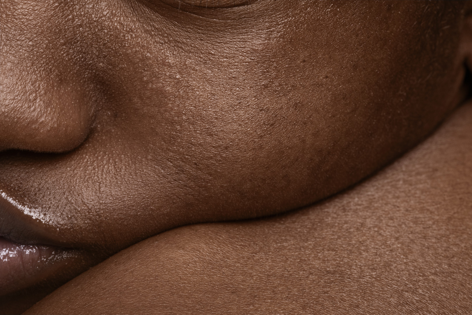 Detailfoto van een gladde, gezonde huid met zichtbare pori&euml;n en natuurlijke glans, benadrukt de huidkwaliteit en verzorging.