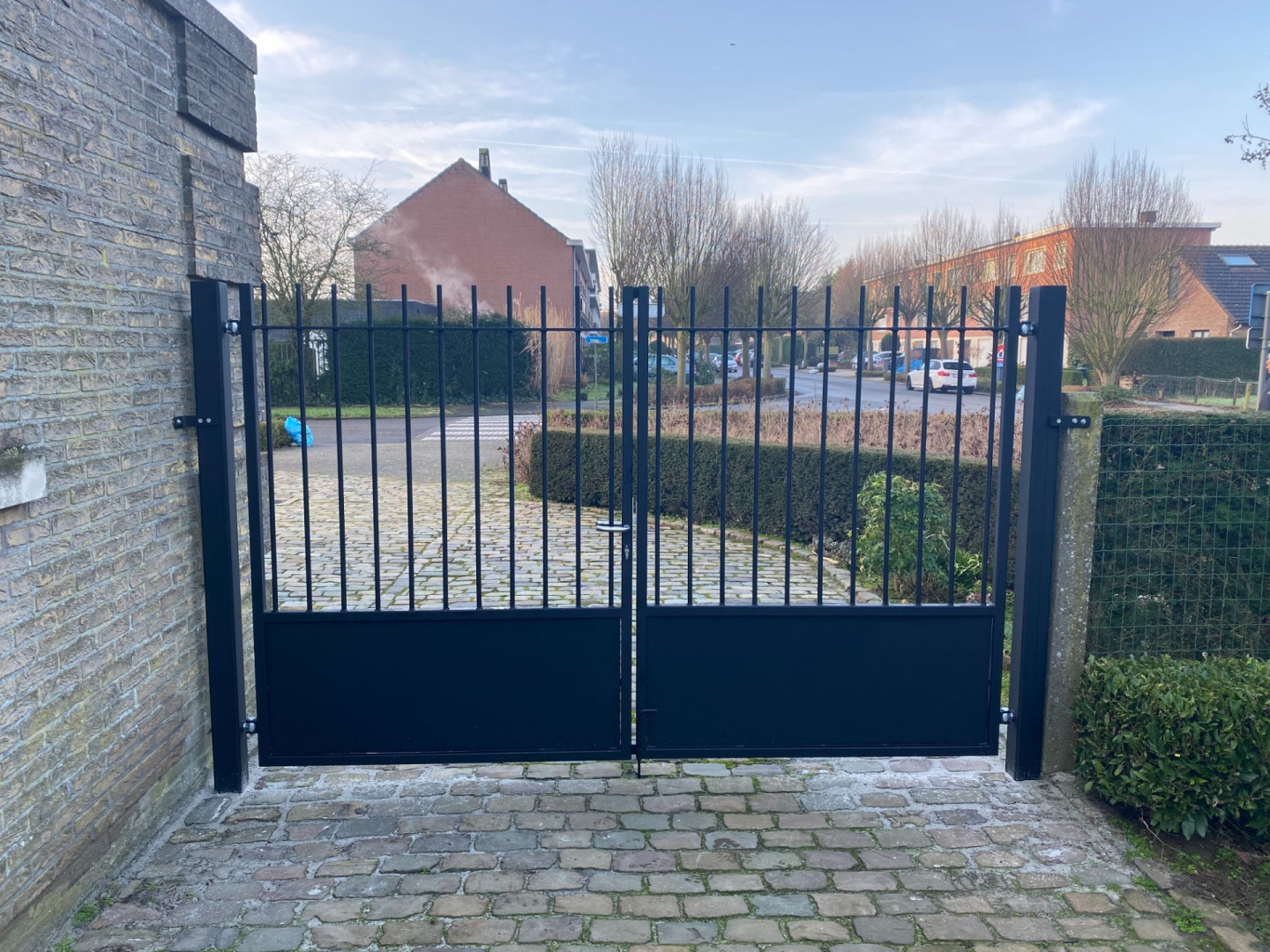 Zwarte moderne poort bij inrit huis