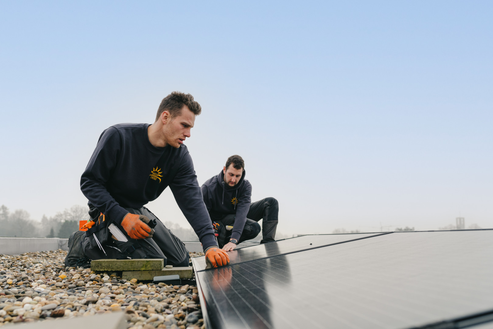Twee installateurs plaatsen zonnepanelen op dak